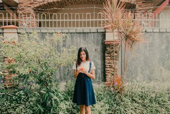 Woman Standing in Front of Gray Concrete Wall