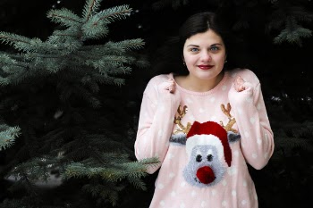 Woman Standing in Front of Green Christmas Tree