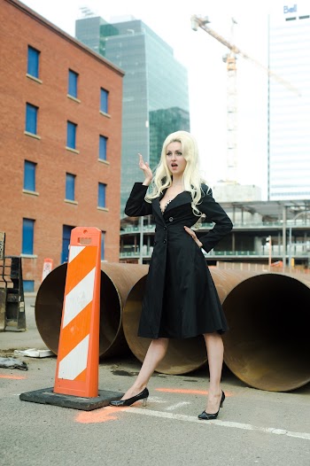 Woman Standing In Front Of Large Metal Pipes