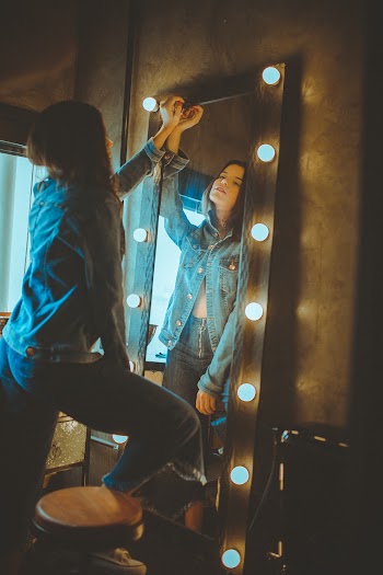 Woman Standing in Front of Leaning Mirror