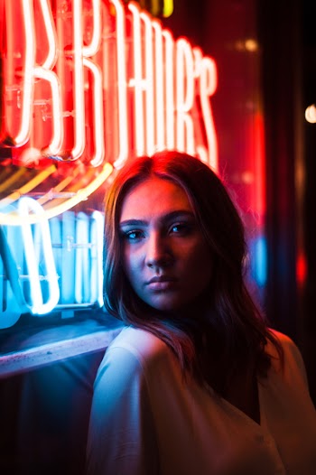 Woman Standing in Front of Lighted Neon Light Signage