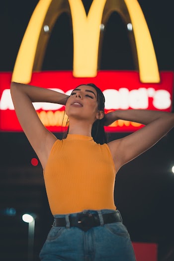 Woman Standing in Front Of Mcdonalds During Night Time