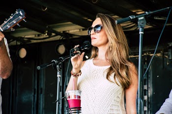 Woman Standing in Front of Microphone While Holding It