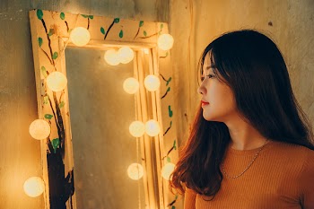 Woman Standing In Front Of Mirror
