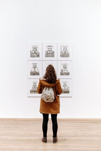 woman standing in front of painting inside the building