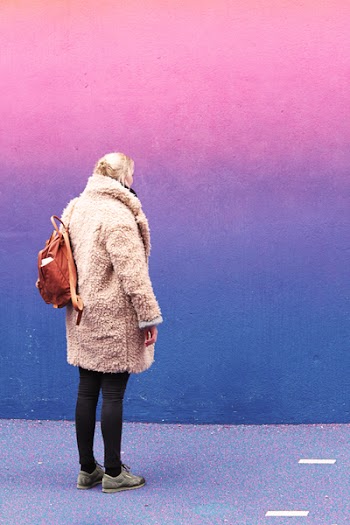 Woman Standing in Front of Pink and Blue Wall