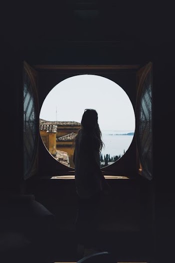 woman standing in front of round window