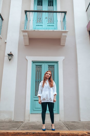 Woman Standing in Front of Teal Wooden Door
