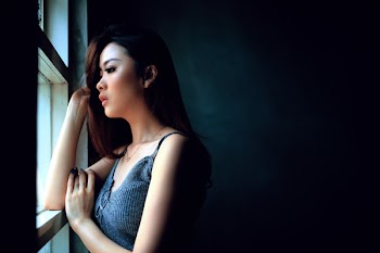 Woman Standing in Front of the Window