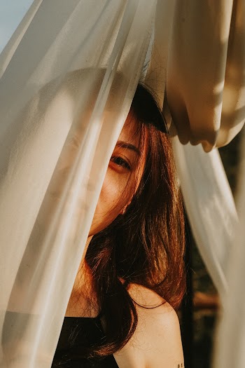 Woman Standing in Front of White Sheer Curtains
