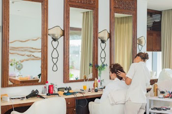 Woman Standing in Front of Woman Sitting on Chair Inside Room