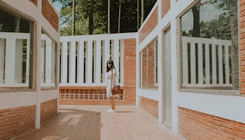 Woman Standing in the Middle of Brick Wall House