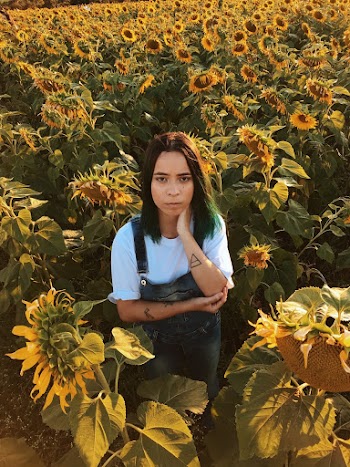 Woman Standing In The Middle Of The Sunflower Field