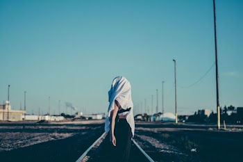 woman standing in the middle of train rail