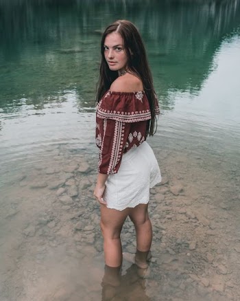 woman standing in water barefooted during daytime