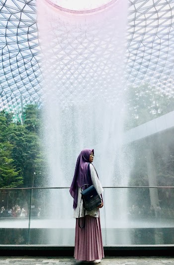 Woman Standing Inside Airport With Fountain