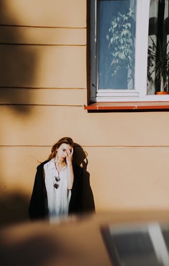 woman standing leaning on concrete wall