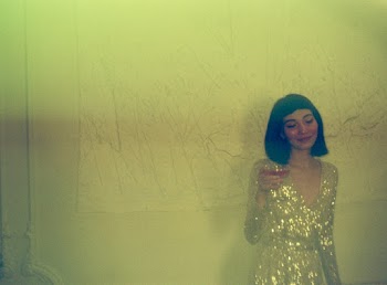 Woman Standing Leaning on Wall Holding Wine Glass