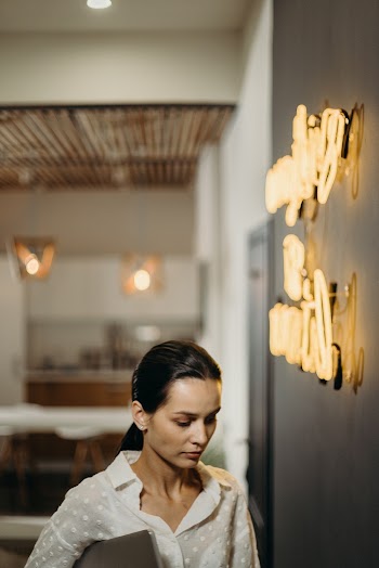 Woman Standing Near A Wall With Illuminated Sign
