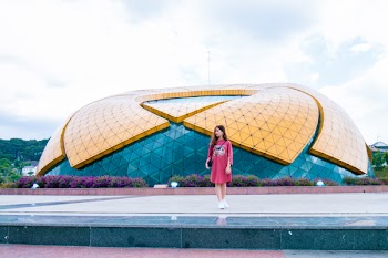 Woman Standing Near Blue and Yellow Dome Under White Cloudy Skies at Daytime