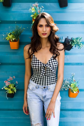 Woman Standing Near Blue Wall with Mounted Potted Plants