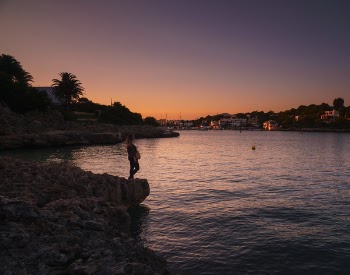 Woman Standing Near Body of Water at Night