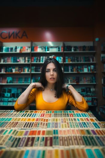 woman standing near books inside room