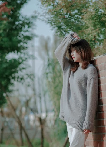 Woman Standing Near Brick Wall