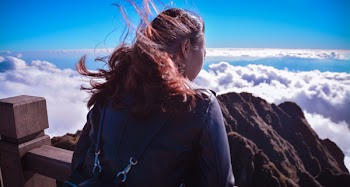 Woman Standing Near Cliff Above Clouds