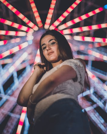 Woman Standing Near Ferris Wheel at Night