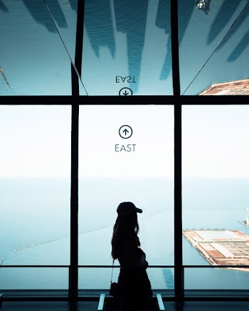 Woman Standing Near Full Glass Window