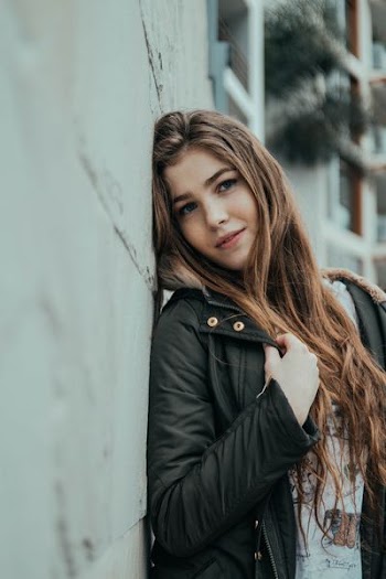 woman standing near gray concrete wall