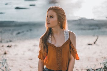 woman standing near green grass looking upward