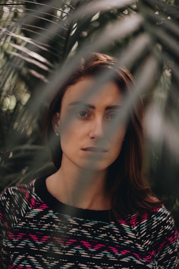 Woman Standing Near Green Palm Plant
