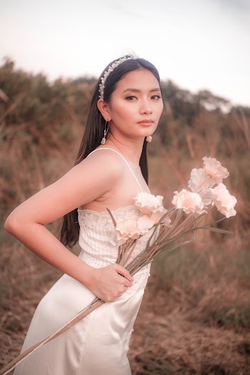 Woman Standing Near Outdoor Holding White Petaled Flowers