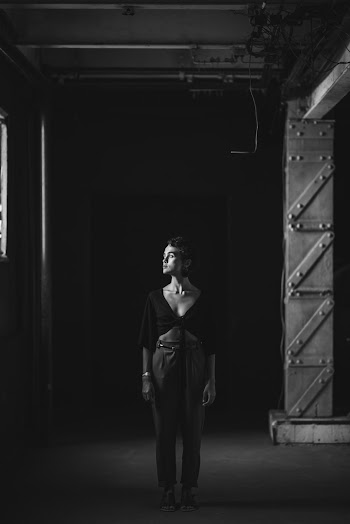 Woman Standing Near Pillar Grayscale Photography