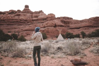 Woman Standing Near Tent and Rock Formation
