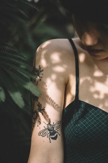 woman standing near tree while looking at shoulders