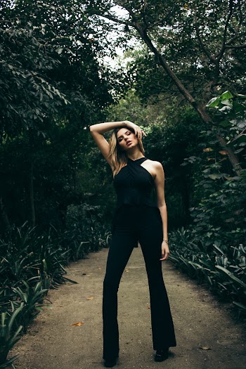 Woman Standing Near Trees While Holding Her Head