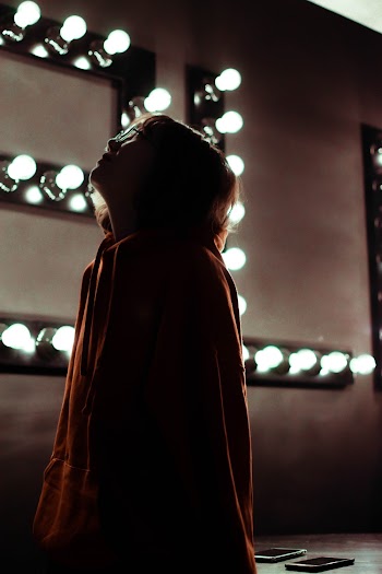 Woman Standing Near Turned-On Light Bulbs
