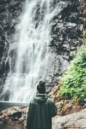 woman standing near waterfalls