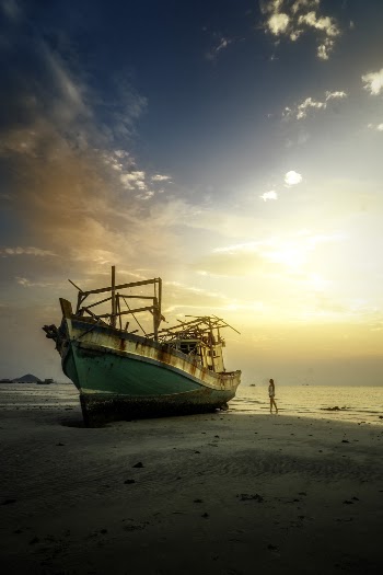 Woman Standing Near White and Green Ship by the Seashore
