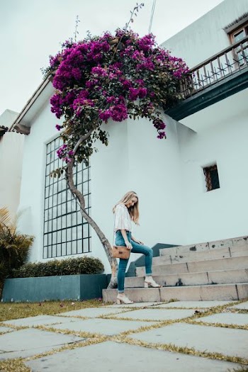 woman standing near white concrete house