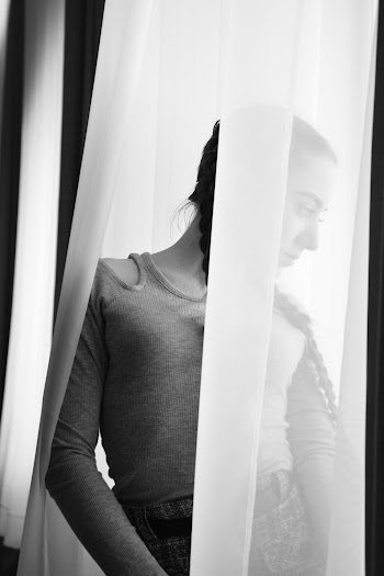 Woman Standing Near White Curtain