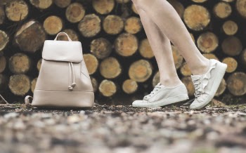 Woman Standing Near White Leather Backpack