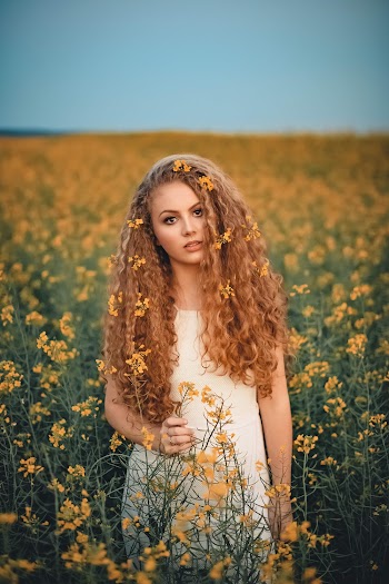 Woman Standing On A Field Of Flowers
