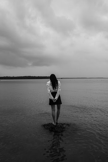 Woman Standing On A Rock In A Body Of Water