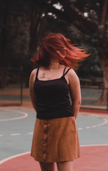 Woman Standing On Basketball Court With Arms On Her Back
