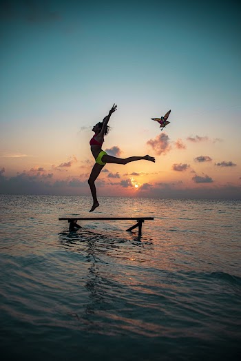 Woman Standing on Bench on Body of Water