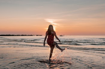 Woman Standing on Body of Water during Golden Hour